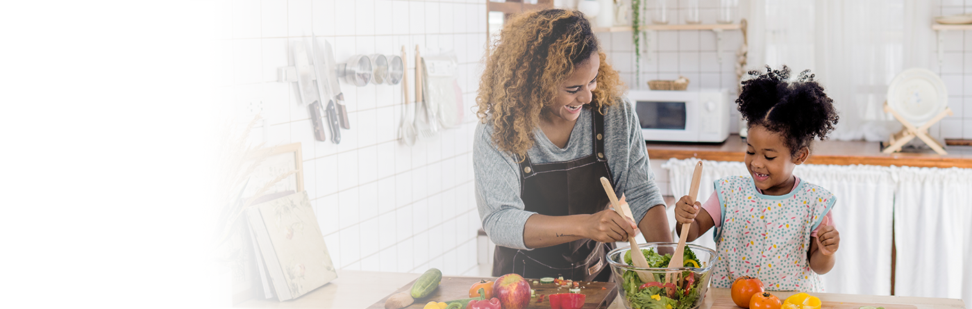 Girl learning to prepare meal from-mother